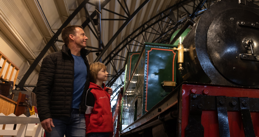 A father and son looking at a train on display at Ulster Transport Museum, Cultra